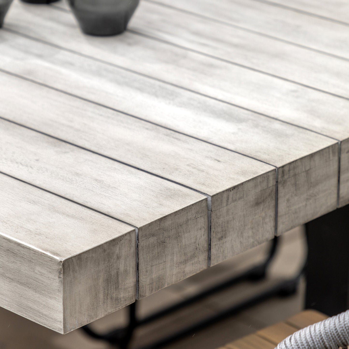 Gallery Garden Taranto 8 Seater Dining Table is constructed from a grey toned acacia wood with slatted table top, and black iron U legs