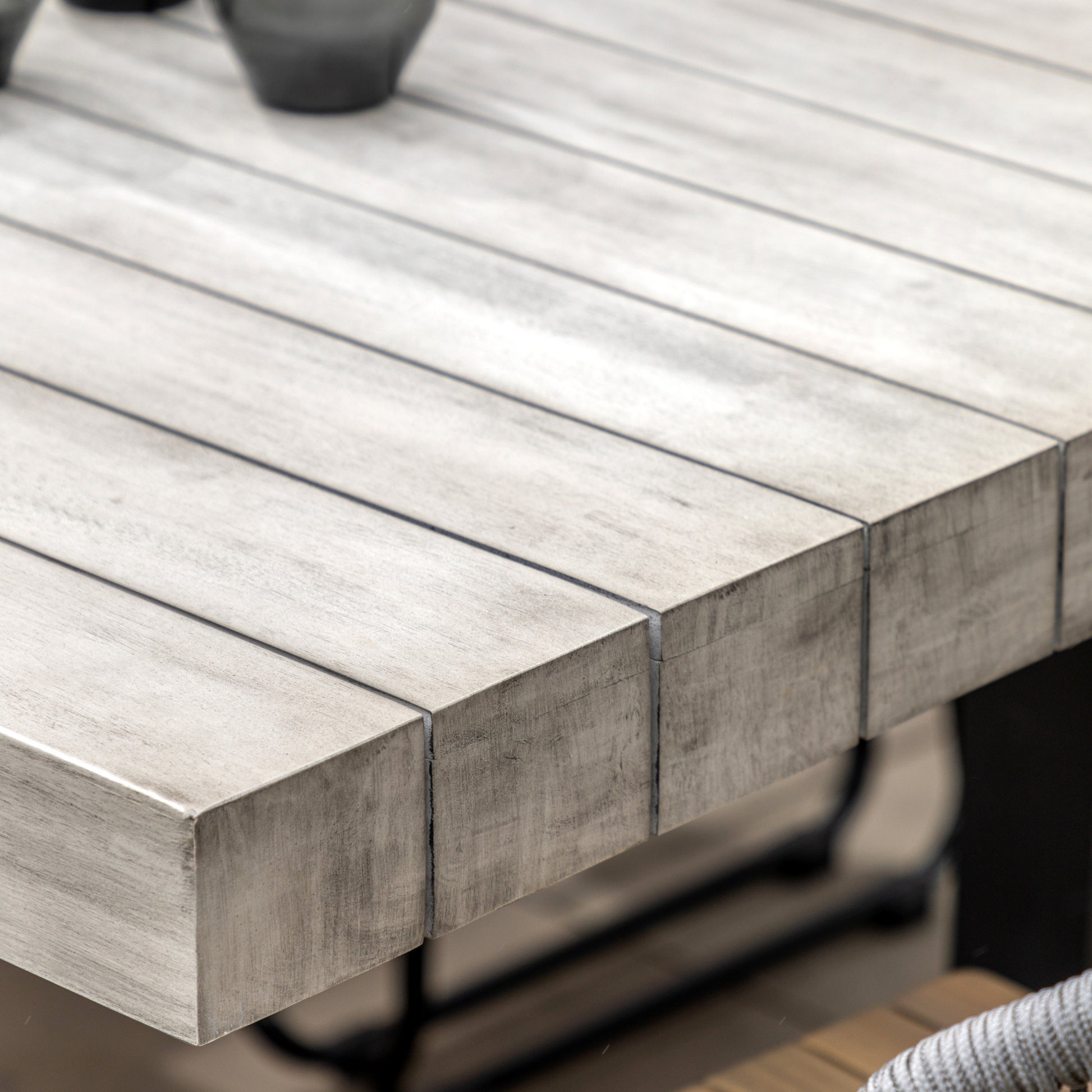 Gallery Garden Taranto 8 Seater Dining Table is constructed from a grey toned acacia wood with slatted table top, and black iron U legs