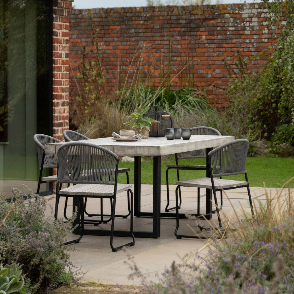 Gallery Garden Taranto 6 Seater Rectangular Dining Table constructed from grey toned acacia wood with a slatted table top, and black powder coated iron legs. Chairs available separately 