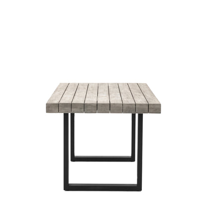 Gallery Garden Taranto Dining Table 6 Seater constructed from grey slatted acacia wood, with black powder coated iron U shaped legs