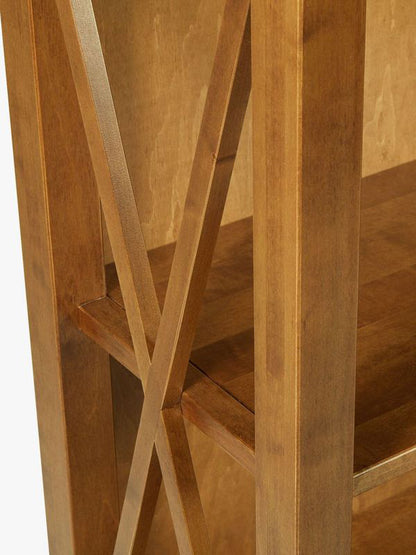 Laura Ashley Balmoral single bookcase with warm honey coloured finish featuring four open shelves, cross-frame side detailing and two lower drawers for storage.