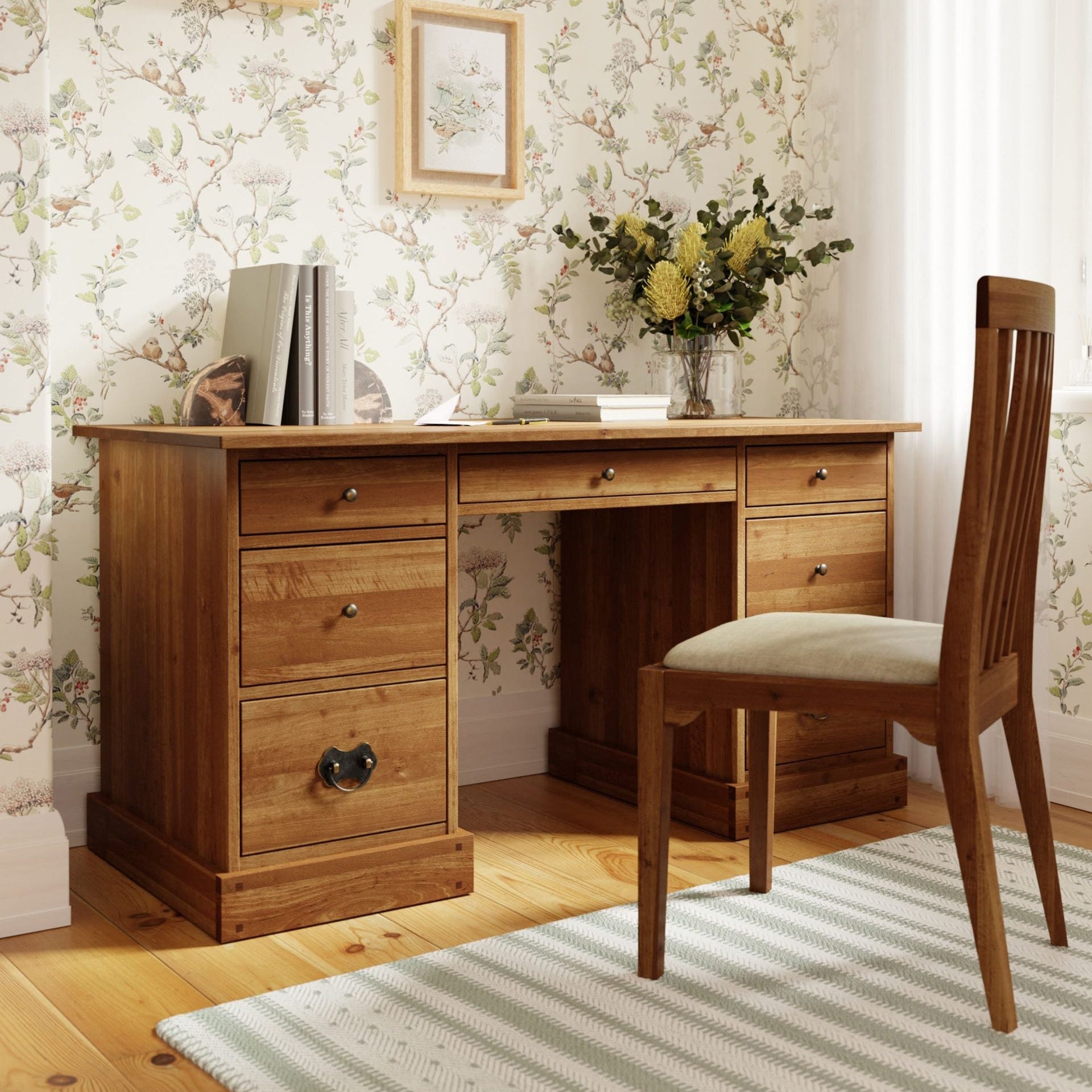 Laura Ashley Garrat Honey 7 Drawer Desk made from a warm honey coloured solid birch wood with 3 drawers on each side and a narrow drawer in the centre, all with metal handles
