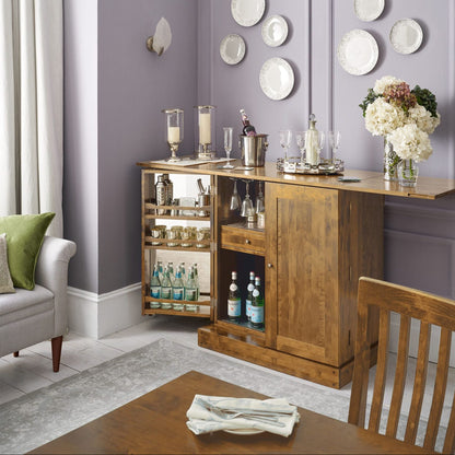 Laura Ashley Garrat honey drinks cabinet with fold-out bar top for serving, cabinet doors open to reveal mirrored internal doors, glass racks, shelves, a drawer and bottle storage.