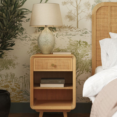 Laura Ashley Millen 1 drawer bedside table crafted from solid oak and oak veneer with rattan drawer front, gold handles and two open shelves