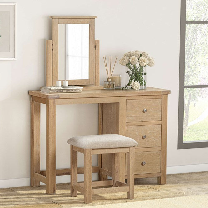 The Papaya Foxington Dressing Table Set features a three drawer dressing table and matching tilting mirror, plus an upholstered stool, all crafted from solid natural oak