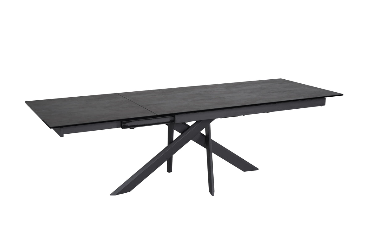 Angled studio view of the Ravenna Dining Table in Ceramic Volcano, showing its dark patterned top and black angular base.