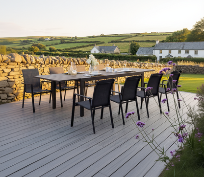 The Royal Garden Catala Extending Dining Set features 8 stackable chairs and a generous extending dining table with a grooved, wood-effect table top in a charcoal grey finish