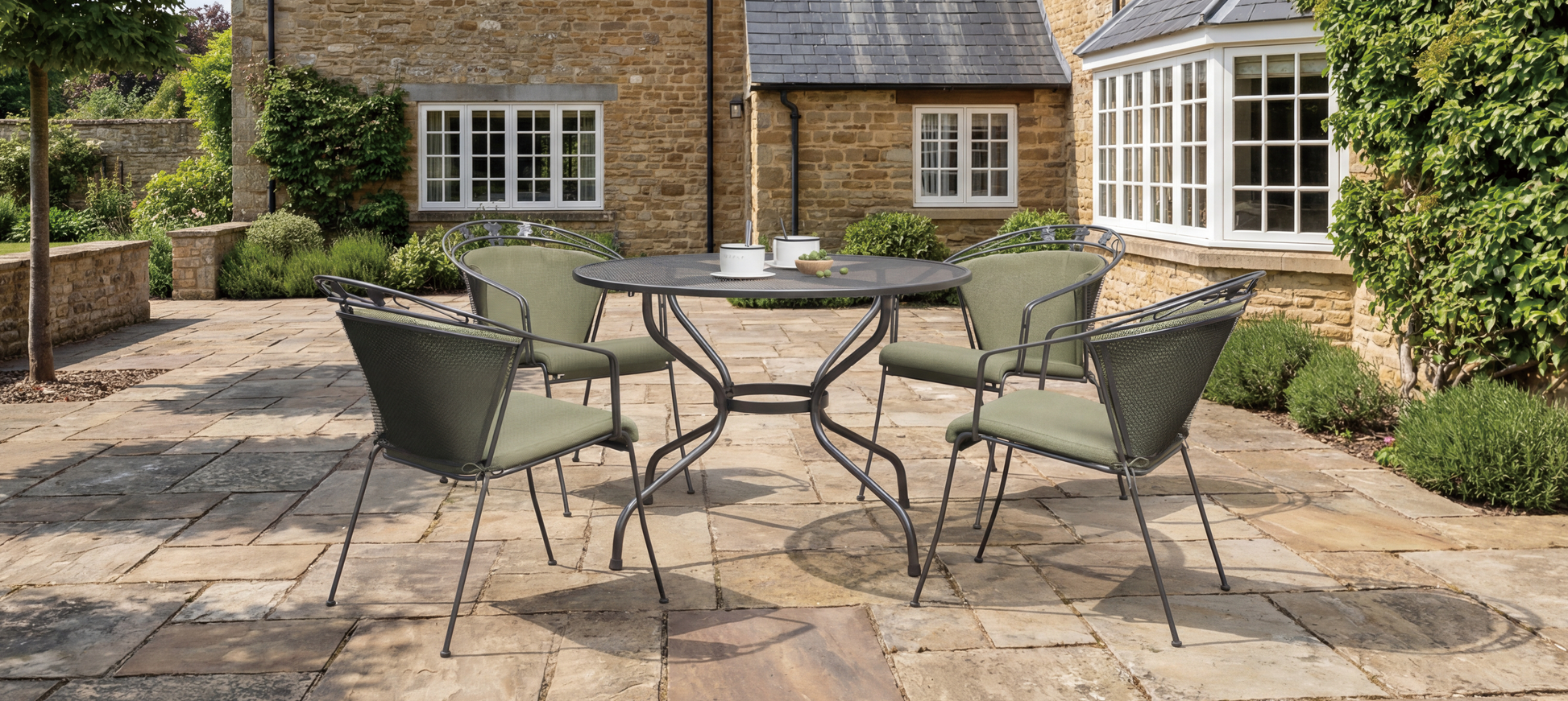 Royal Garden Elegance Dining Set features a round aluminium table with parasol hole and 4 elegant detailed chairs with green padded cushions