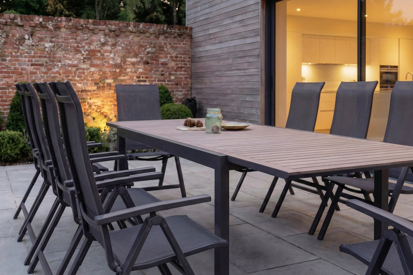The Royal Garden Vidoo 10 Seat Extending Dining Set features a charcoal grey aluminium frame, extendable dining table with slatted table top, and 10 multi position reclining chairs 