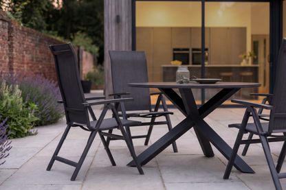Royal Garden Vidoo 4 Seat Round Dining Set features a sleek charcoal grey cross legged table and 4 reclining dining chairs 
