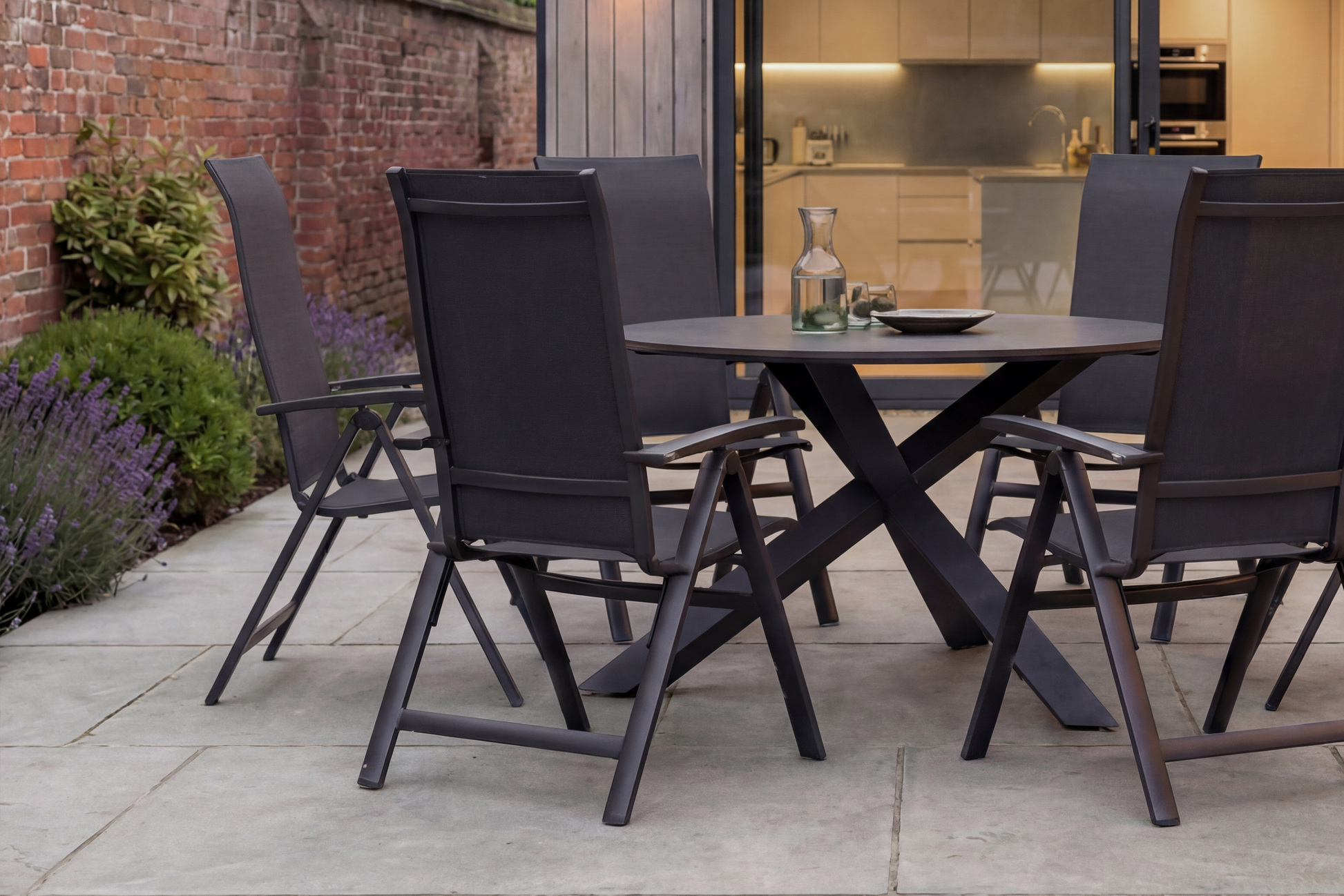 The Royal Garden Vidoo 6 Seat Round Dining Set features a sleek charcoal grey round table and 6 multi position reclining chairs with textilene fabric seats