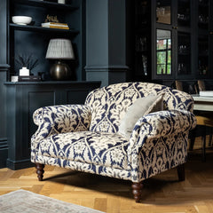 Tetrad Tallis Snuggler Sofa in Enigma Indigo blue and cream damask upholstery with scrolled arms and dark wooden legs