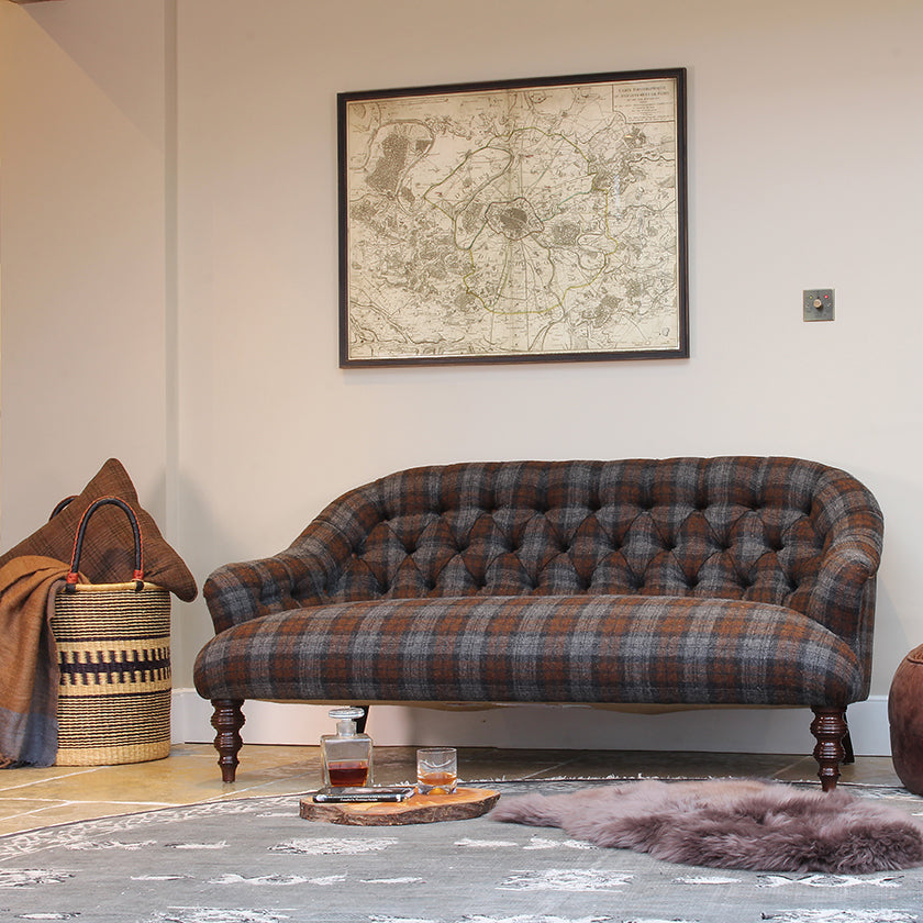 Tetrad Arbelour Petit Sofa in Macallan Check Fabric with grey, blue and brown tones, deep button tufting to the back, a generous seat depth and Dark Mahogany Turned Feet