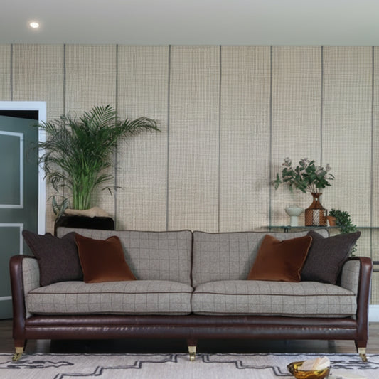 Tetrad Balmoral Grand Sofa in Austin Cumin Seed & Munro Check upholstery with coordinating scatter cushions, a rich brown leather covered frame and side panels, and dark wooden feet with castors