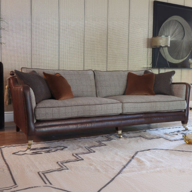 Tetrad Balmoral Midi Sofa in Austin Cumin Seed & Munro Check fabric with matching scatter cushions. Rich brown leather panels and dark wooden legs with castors create a sophisticated look
