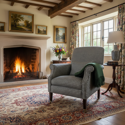 Tetrad Bowmore Armchair upholstered in Ebony Hounds Harris Tweed, charcoal grey and cream check, features rolled arms, a deep sprung seat and dark wood legs with castors on the front legs