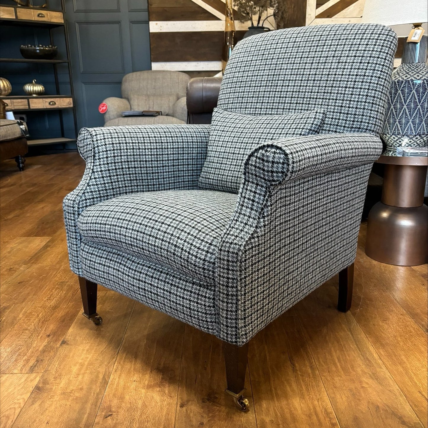 Tetrad Bowmore Ebony Hounds Harris Tweed accent armchair, in charcoal and cream houndstooth check with dark brown wood legs and brass castors to the front