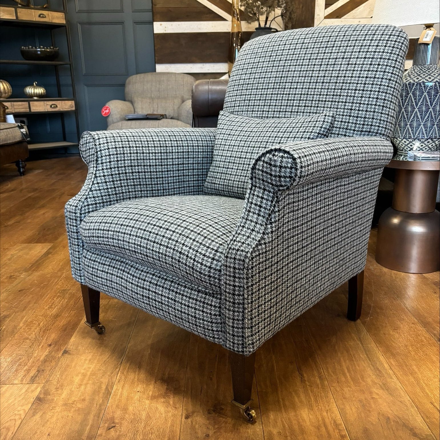 Tetrad Bowmore Ebony Hounds Harris Tweed accent armchair, in charcoal and cream houndstooth check with dark brown wood legs and brass castors to the front
