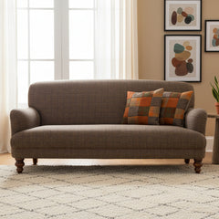 The Tetrad Braemar Midi Sofa in genuine Harris Tweed in charcoal grey/brown tones with vibrant orange patchwork scatter cushions and dark wood turned feet