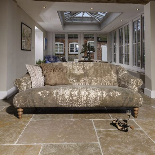 Tetrad Jacaranda Petit Sofa upholstered in a Bagru hand-block printed fabric in sophisticated khaki and cream colours, with scrolled arms and natural turned wood legs