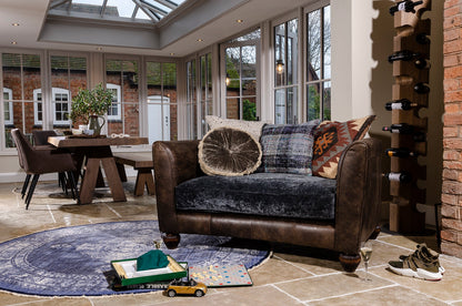 Tetrad Lowry Snuggler Sofa seats 1-2 people and is handcrafted in a premium Leather and sumptuous crushed Velvet, with a selection of scatter back cushions