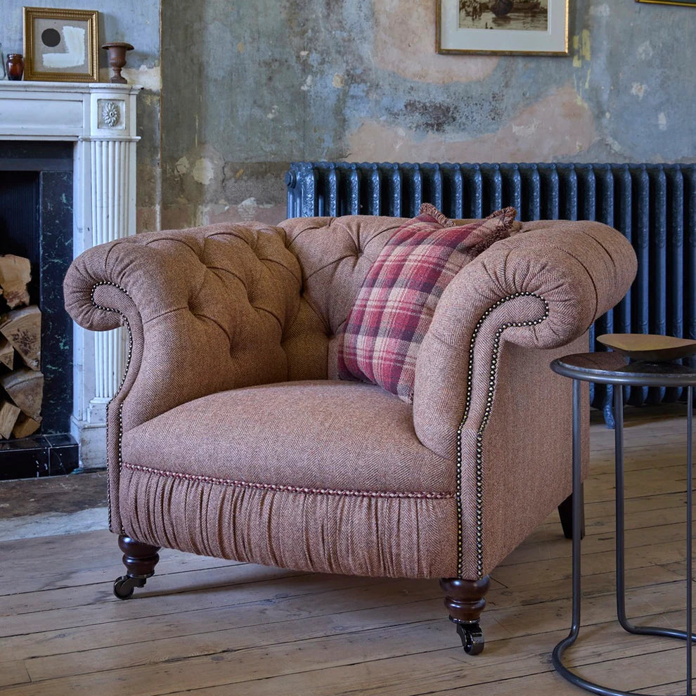 Tetrad Melrose Chair in Jura Rose combines a classic chesterfield inspired design with deep button tufting, decorative stud detailing and turned wood feet with castors to the front