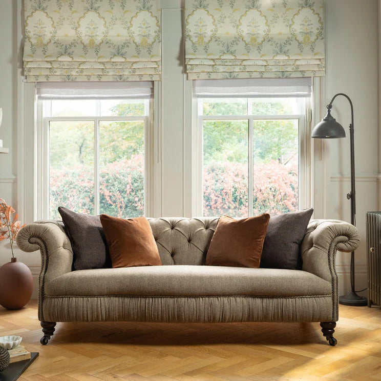 Tetrad Melrose Midi Sofa in Jura Stag features a classis chesterfield inspired design in neutral tones, with deep button tufting, stud detailing and turned wood feet with castors