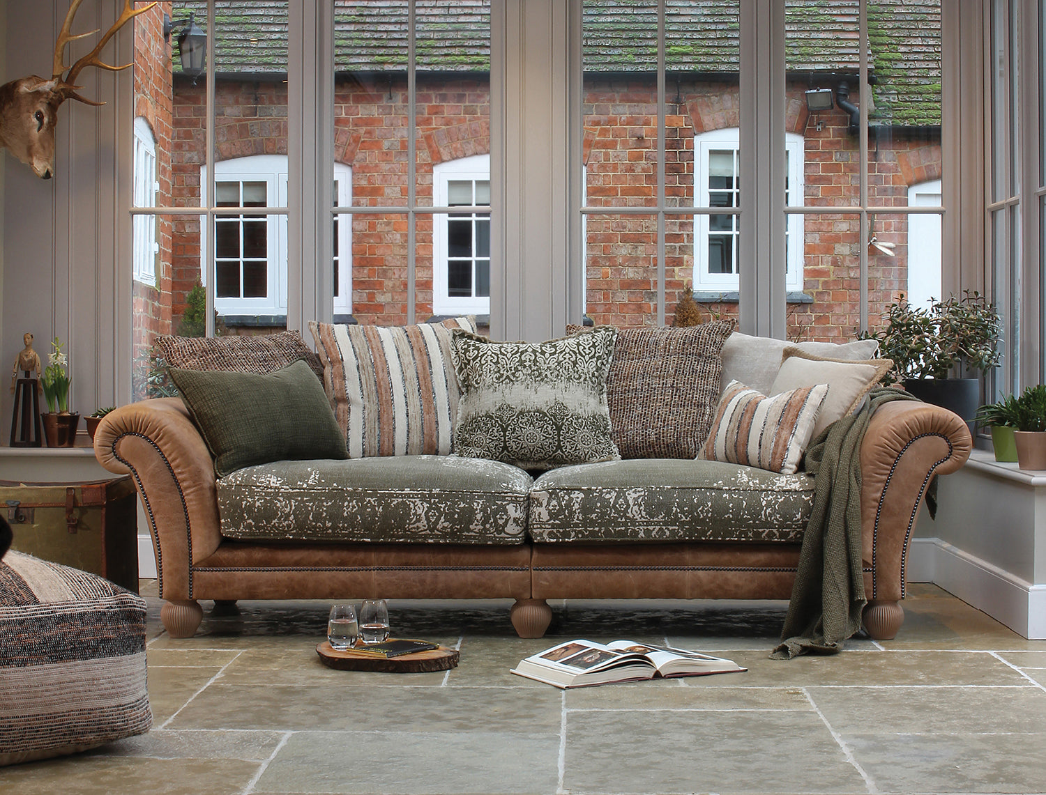 Tetrad Montana Grand Sofa in Atacama Nutmeg Leather, features patterned fabric seats, nutmeg tan arms with brass stud detail and coordinating scatter cushions