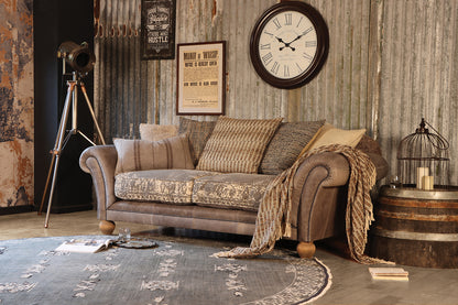 Tetrad Montana Midi Sofa for 2-3 people in Atacama Pewter Leather, with crushed velvet seat cushions in a champagne gold colour palette, decorative stud detailing and traditional Bun feet