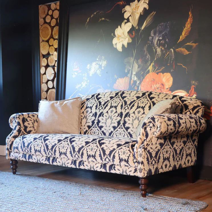Tetrad Tallis Grand Sofa in Enigma Indigo damask patterned fabric with scrolled arms and dark wooden legs, plus cream scatter cushions