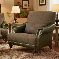 Tetrad Taransay Gentleman's Chair in a neutral tone mixed fabric and rich olive green leather, with dark wooden legs and front castors