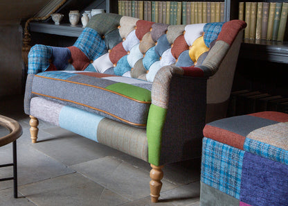 Vintage Sofa Company Alsace Patchwork Petit Sofa seats 2 people and features a generously padded seat cushion with tan leather trim, the backrest has deep button tufting with patchwork upholstery 