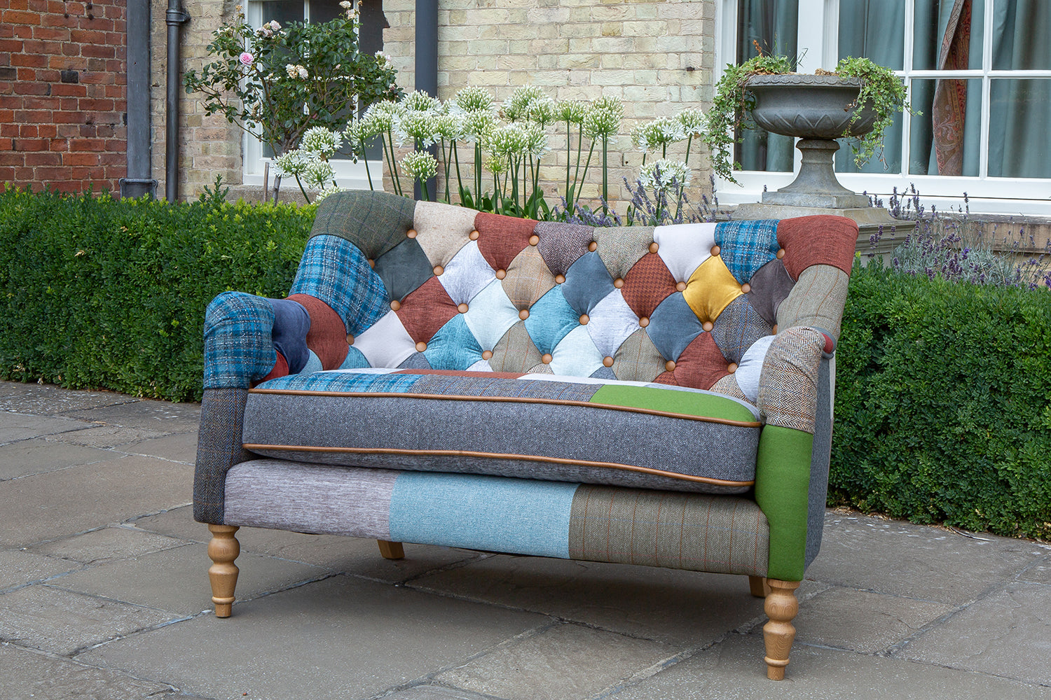 Vintage Sofa Company Alsace Patchwork Petit 2 Seater Sofa with its deep buttoned back, rolled arms and turned wooden legs, it has the charm of a traditional sofa with a more playful, individual finish.