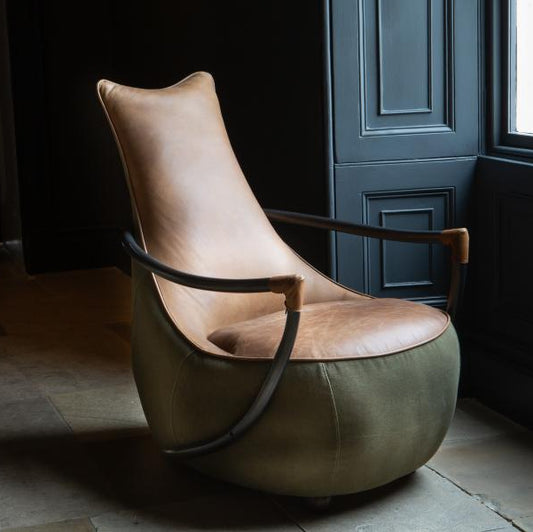 Vintage Sofa Company Apache Chair combines washed green canvas with warm tan leather for a more design-led take on relaxed seating. Its tall back, curved arms and rounded silhouette give it strong visual presence
