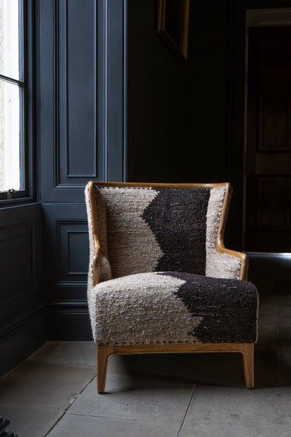 Vintage Sofa Company Ballari Chair features a striking mix of sculptural woodwork and richly textured upholstery, in a cream and charcoal bouclé-style finish with an exposed wooden frame that adds definition and character.