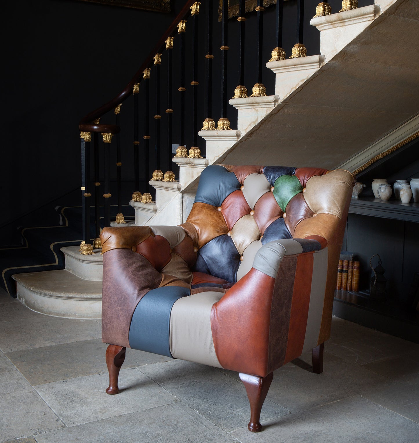 Vintage Sofa Company Bamford Leather Patchwork Armchair with deep button tufting, dark wood legs and panelled leather to the sides