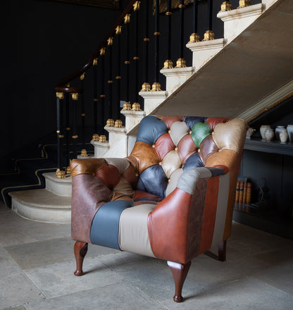 Vintage Sofa Company Bamford Leather Patchwork Armchair with deep button tufting, dark wood legs and panelled leather to the sides