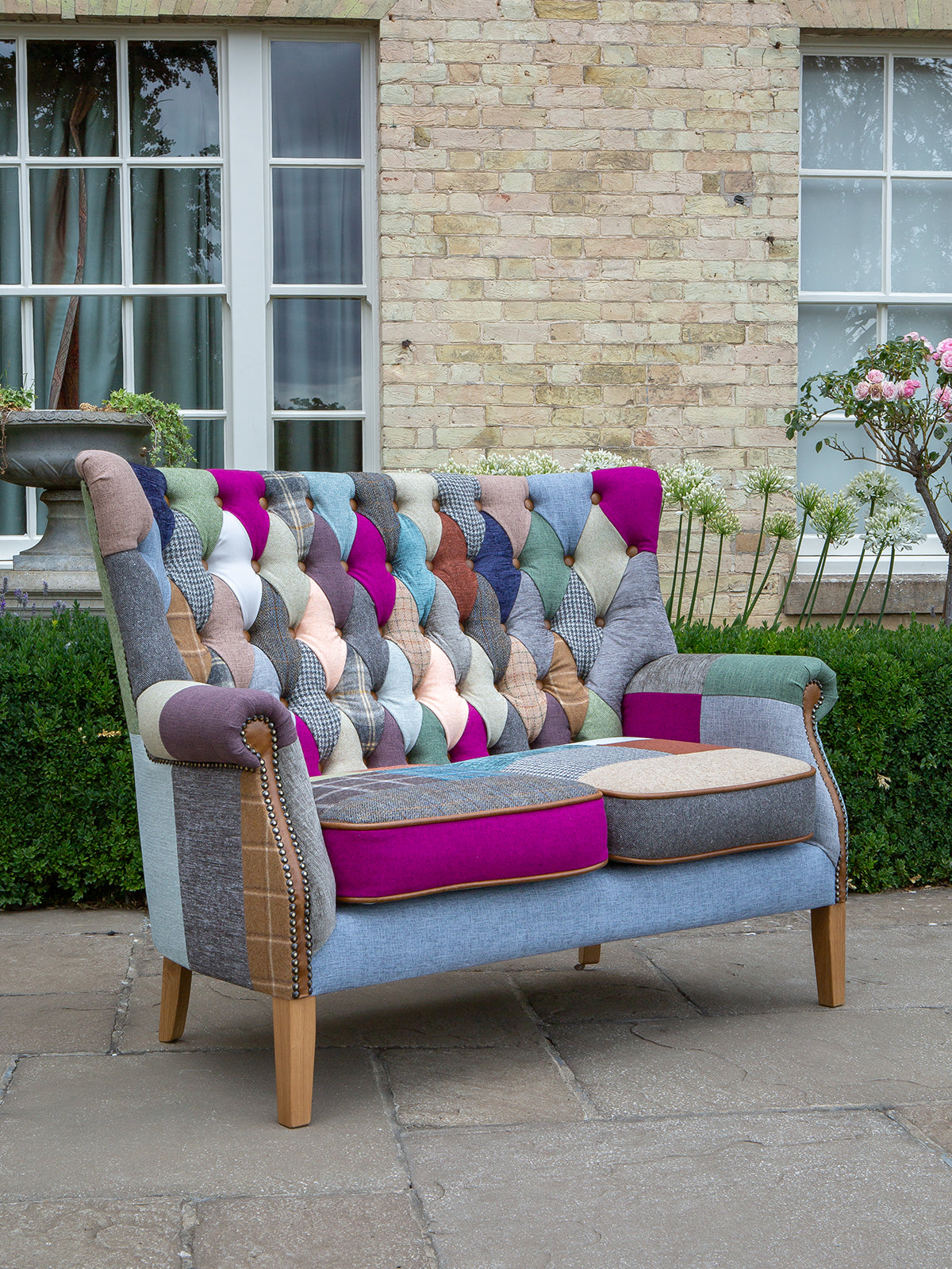 Vintage Sofa Company Barnard 2 Seater Sofa features a patchwork mix of velvets, tweeds, checks and textured weaves with deep button tufting to the high backrest and brass stud detailing on the scrolled arms 