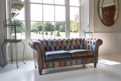 Vintage Sofa Company Chester Croft Rub Off Leather Patchwork 2 Seater Sofa with its chesterfield inspired design features deep button tufting, rolled arms, brass stud details and turned wooden feet