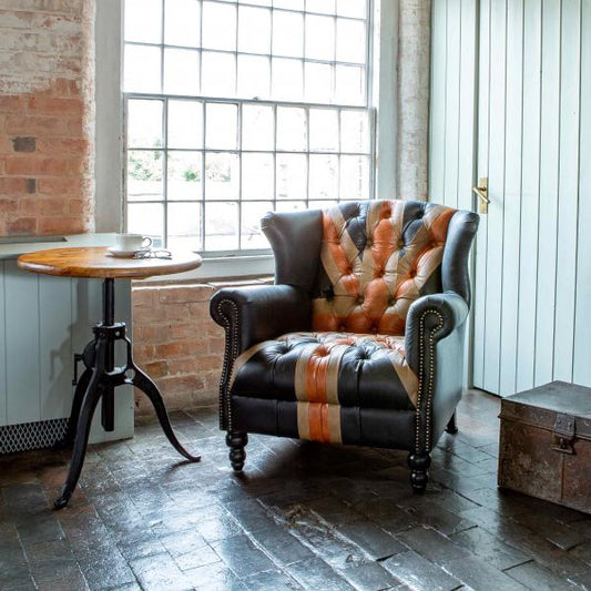 Vintage Sofa Company Crompton Union Jack Leather Armchair in Leather brings a familiar British motif into a properly upholstered statement chair. With its high back, deep buttoning, navy, red and tan leather panels, studded scroll arms and turned wooden legs.