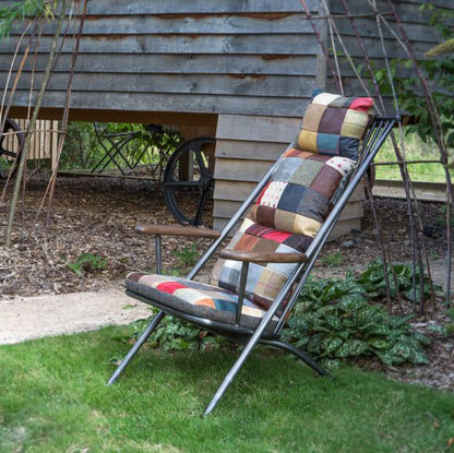 Vintage Sofa Company Ely Patchwork Studio Chair features a black metal reclining frame that can be folded for storage, and a vibrant patchwork padded upholstery with bohemian flair
