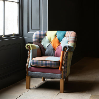 The Vintage Sofa Company Governor Armchair is upholstered in a vibrant Patchwork fabric with tan leather accents and brass stud detailing 