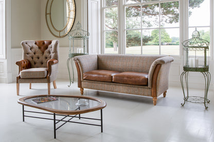 Vintage Sofa Company Granby 2 Seater Plain Back Sofa with a neutral fabric upholstery and warm tan Leather seat cushions, rolled arms and turned wooden legs