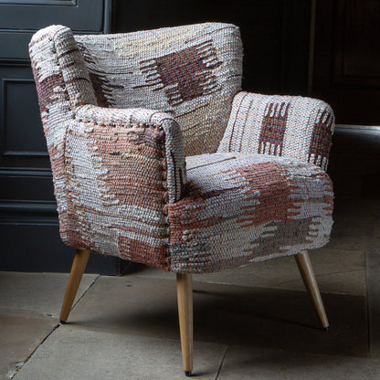 Vintage Sofa Company Hansi Chair features a textured woven fabric with soft muted tones in an abstract pattern, with brass stud detailing and tapered light wooden legs