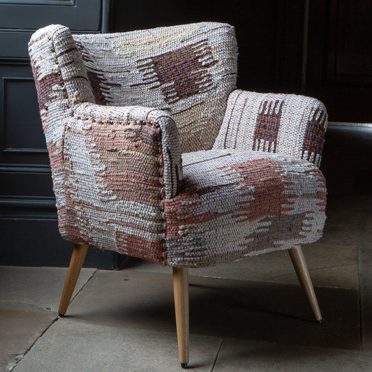 Vintage Sofa Company Hansi Chair features a textured woven fabric with soft muted tones in an abstract pattern, with brass stud detailing and tapered light wooden legs
