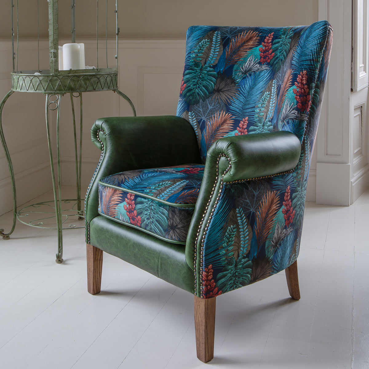 Vintage Sofa Company Hexham Arm Chair in Kingfisher Fabric and Bottle Green Leather upholstery with brass stud details and dark wooden legs 