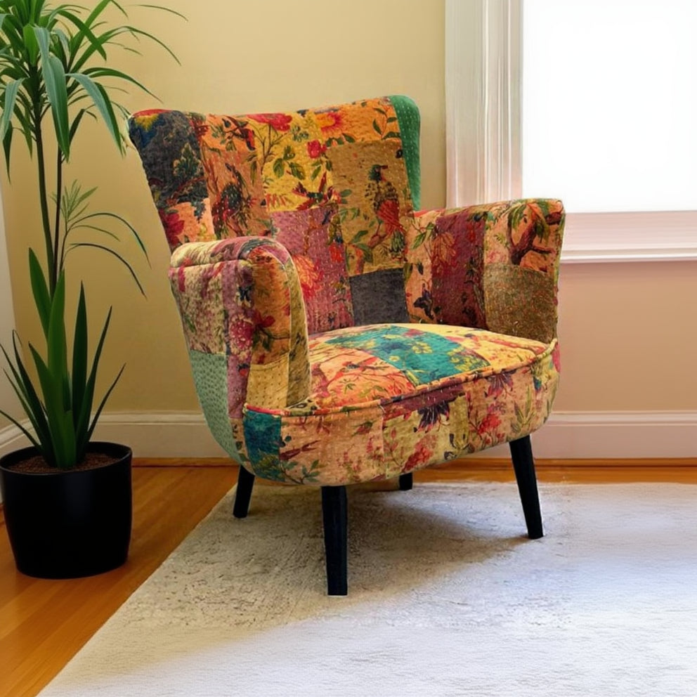 Vintage Sofa Company Kari Patchwork Chair features a mix of floral fabrics in pink, orange, yellow and green with a neat wingback shape and dark wooden legs for a compact statement chair.