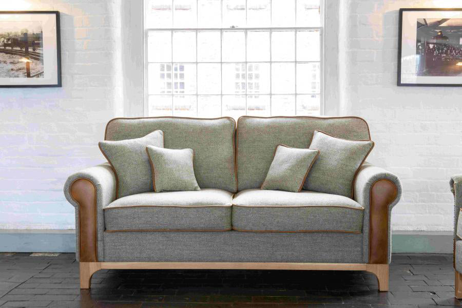 Vintage Sofa Company Lowther 3 Seat Sofa in Lowland Thistle Harris Tweed Fabric with tan leather panels and trim, matching scatter cushions and a light wooden base 