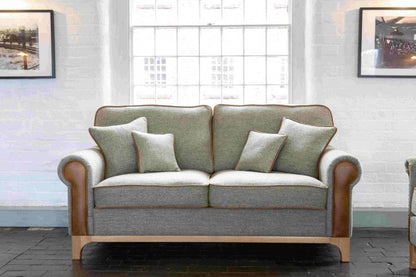 Vintage Sofa Company Lowther 3 Seat Sofa in Lowland Thistle Harris Tweed Fabric with tan leather panels and trim, matching scatter cushions and a light wooden base 