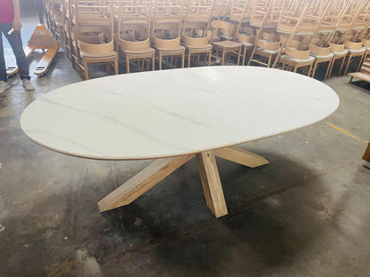 Carlton Furniture Barkington Sintered Stone Dining Table - angled factory view of oval top and wooden spider legs